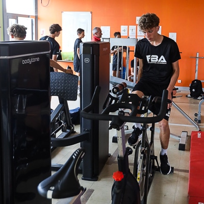 salle de musculation, joueur de football sur vélo